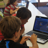 Ignite Creative Learning classroom photograph 1 of 8 showing hands-on programming instruction at computers.